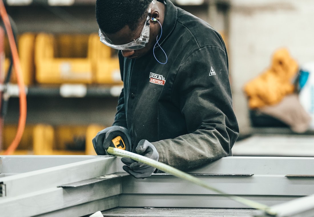 Ouvrier mesurant un profilé métallique dans un atelier de fabrication